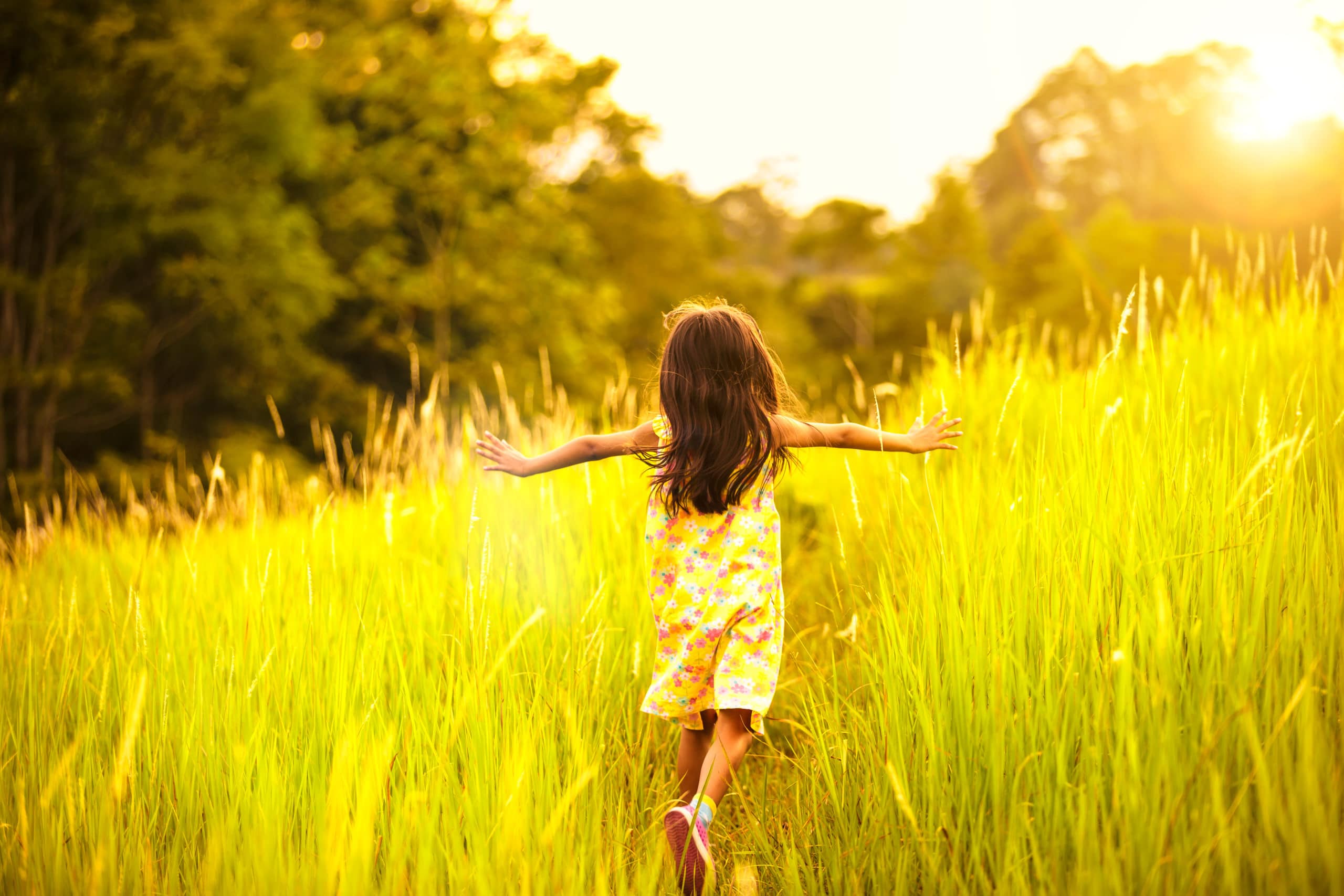 young girl running through field